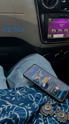 a cell phone sitting on top of a blue blanket next to a car dash board