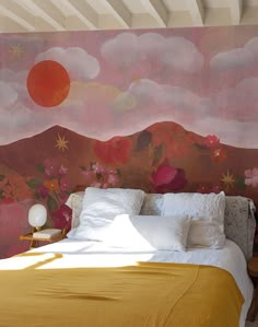 a large bed sitting under a painting on the side of a wall next to a night stand