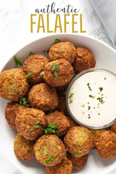 a white bowl filled with falafel next to a cup of ranch dressing