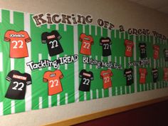 a bulletin board with football jerseys and numbers on it in the hallway at an elementary school