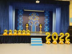 the stage is set up with balloons and decorations for an upcoming year celebration in blue and gold