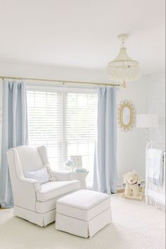 a baby's room with white furniture and blue drapes