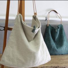 two purses sitting on top of a wooden table