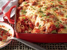 a red casserole dish filled with pasta and meat