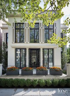 a white house with many windows and plants