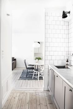 a kitchen with white walls and wooden floors