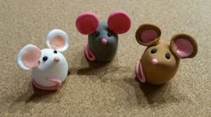 three toy mice sitting on top of a carpeted floor next to each other in different colors