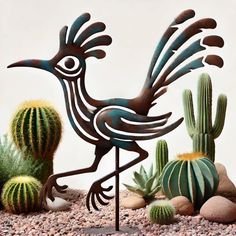 a metal bird standing next to cacti and succulents in the desert