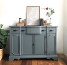 a blue dresser with books and plants on top