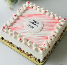 a birthday cake with white frosting and pink icing