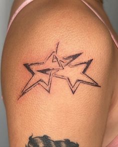 a woman's arm with a star tattoo on the left side of her shoulder