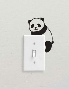 a black and white panda bear on a light switch