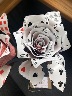 a rose made out of playing cards on top of a table