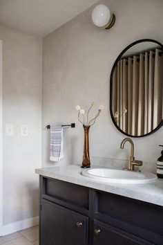 a bathroom with a sink, mirror and towel rack