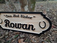 a wooden sign that says, one hot sisters'rovan on it in front of a tree