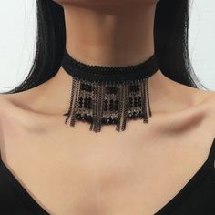 a woman wearing a black choker with beads and chains on the bottom of her neck