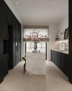 a large kitchen with marble counter tops and black cabinets, along with an island in the middle