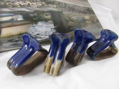 three blue and white ceramic birds sitting on top of a table next to a magazine