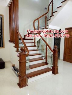 a stair case with glass railing and wood handrails in a house for sale