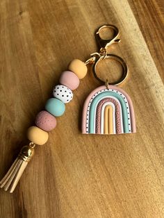 a wooden table with a keychain that has a rainbow and dots on it