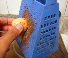 a person is peeling an egg in a blue grater