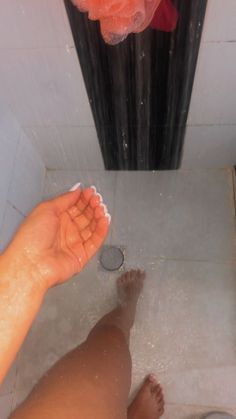 a person is standing in the shower with their feet up