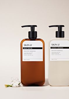 two bottles of skin u hand and body lotion next to each other on a white surface