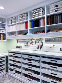 an organized sewing room with white shelving and lots of crafting supplies on shelves