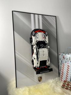 a car made out of legos is displayed in front of a wall with gifts