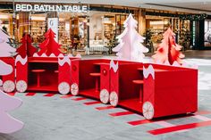 red and white cardboard christmas trees in a store