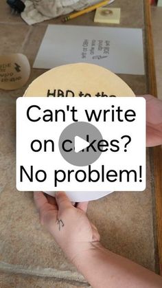 a person holding up a sign that says can't write on cakes? no problem