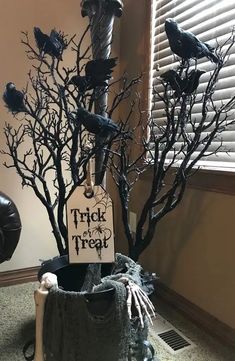 there is a fake tree that has been decorated with black branches and decorations on it