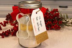 a glass jar filled with sand next to red berries and a tag that says i love you