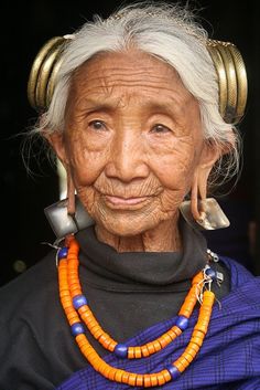 an old woman with white hair and orange beads