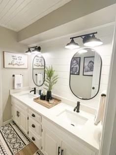 a bathroom with two sinks, mirrors and lights on the wall next to each other