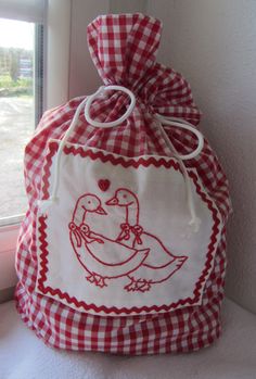 a red and white bag sitting on top of a window sill