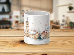 a white coffee mug with a christmas scene on it sitting on top of a wooden table