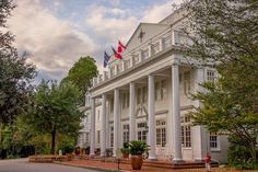 a large white building with columns and flags on top