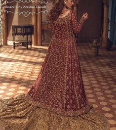 a woman in a maroon and gold gown