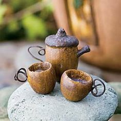 three teapots sitting on top of a rock