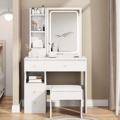 a white dressing table with drawers and a mirror on it in a bedroom next to a bed