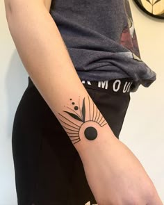 a woman's arm with a tattoo on it and a clock in the background