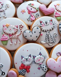 many decorated cookies with cats and hearts on them