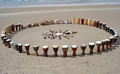 there are many drums arranged in the shape of a circle on the sand at the beach