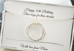 a white box with a silver necklace in it's front and the words, happy 30th birthday there rings for three decades written on it