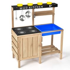 a wooden play kitchen with pots and pans on the stove top, in front of a sign that says mud kitchen