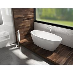 a bathtub sitting on top of a wooden counter next to a window in a bathroom