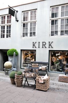 a store front with chairs and tables on the sidewalk in front of it that says kirk