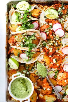 a tray filled with tacos and guacamole