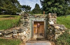 there is a small stone structure with a door in the center and a man's head sticking out of it